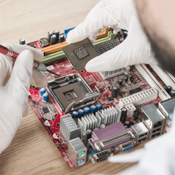 male technician inserting chip computer motherboard wooden desk min